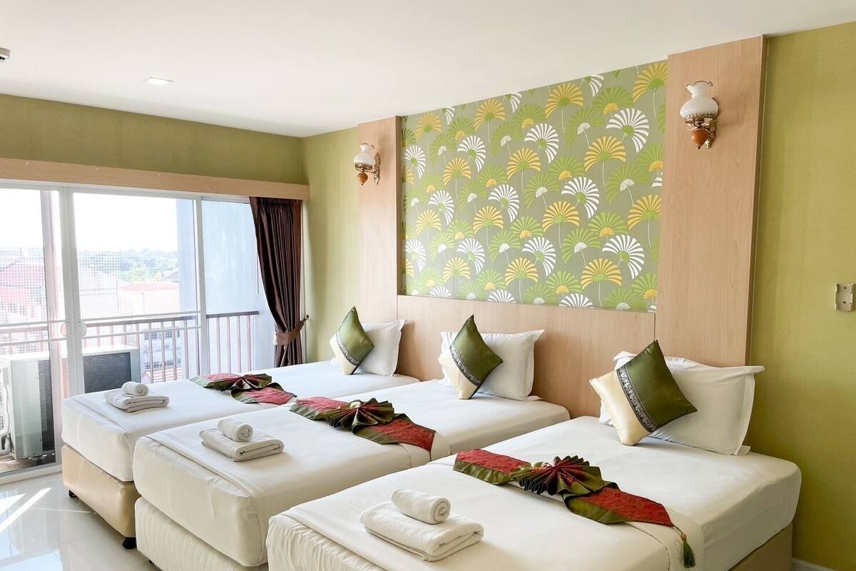 A hotel room with two beds, a large window, and a view of the city.