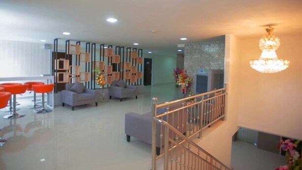 A modern lobby with a staircase, seating area, and decorative wall panels. - Familyhotel (Khon Kaen)