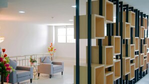 A modern lobby with a seating area, a decorative wall, and a staircase. - Familyhotel (Khon Kaen)