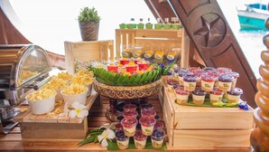A buffet setup with various food items and a decorative centerpiece. - Pranee Amata (Koh Tao)