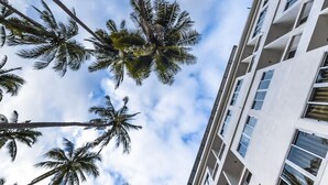 A high-rise building with multiple balconies and a clear view of the sky. - Pranee Amata (Koh Tao)