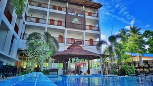 A hotel with a swimming pool, multiple balconies, and a tropical garden. - Pranee Amata (Koh Tao)