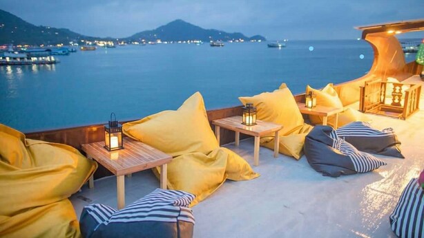 A seaside terrace with seating and lanterns, overlooking a calm sea and distant hills. - Pranee Amata (Koh Tao)