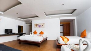 A modern hotel room with a bed, a sofa, and a TV. - Pranee Amata (Koh Tao)