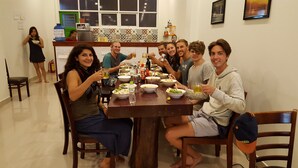 Un grupo de personas cenando en una mesa de madera con diversos platos y bebidas.