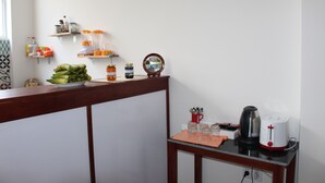 Una zona de cocina con mostrador de madera, cafetera, tostadora y frutero.