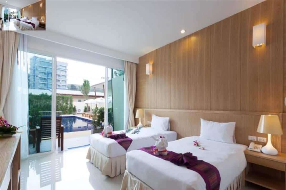 Ein Hotelzimmer mit zwei Betten, einem Balkon und Blick auf die Stadt.