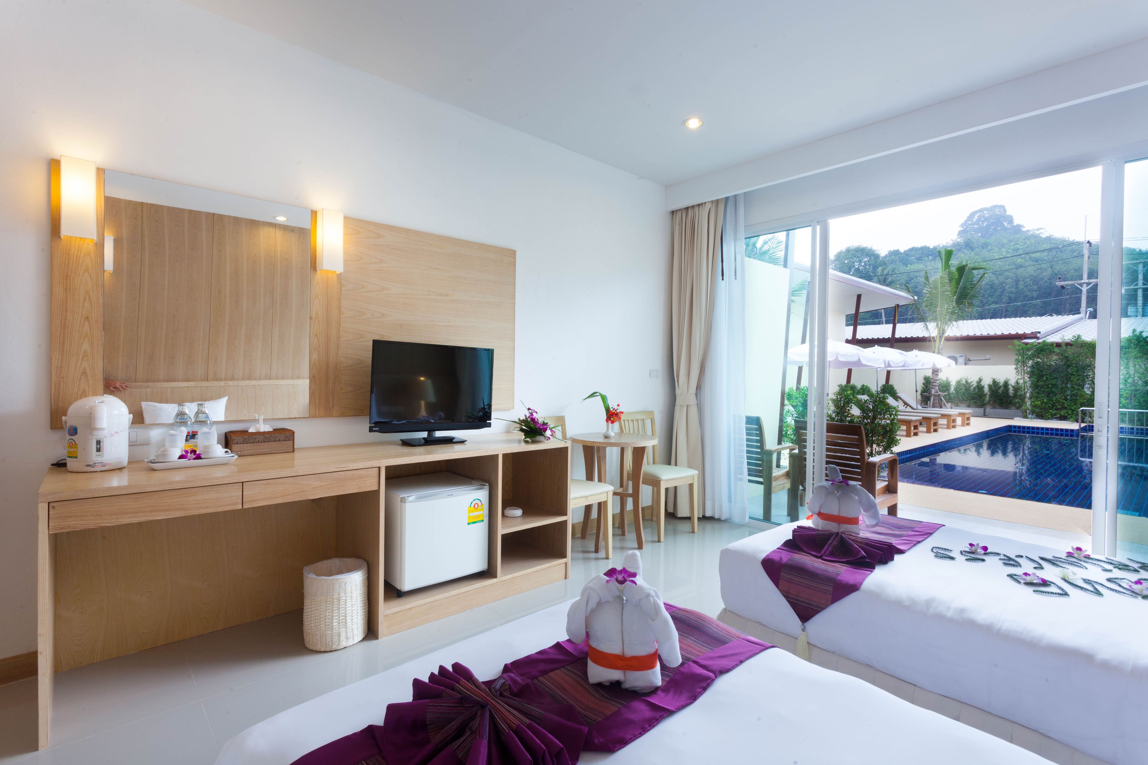 deluxe room, pool view | minibar, in-room safe, desk, blackout curtains