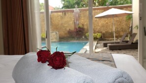 A bed with white towels and two red roses. - Seulawah Grand View (Batu)
