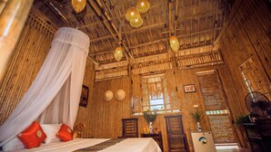 A room with a bed, a desk, and a fan. - Tam Coc Rice Fields Resort (Nam Hoa Lu)