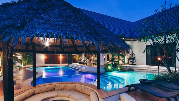 A swimming pool with a thatched roof structure, lounge chairs, and a hot tub area. - Coco Lilly Villas (Ko Pha-ngan)