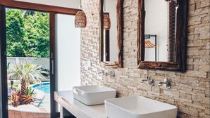 A modern bathroom with two white vessel sinks, a brick wall, and a large mirror. - Coco Lilly Villas (Ko Pha-ngan)