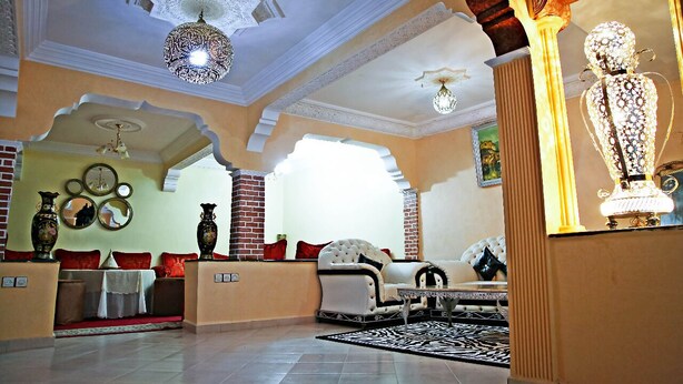 A spacious lobby with a high ceiling, ornate chandeliers, and a large statue.