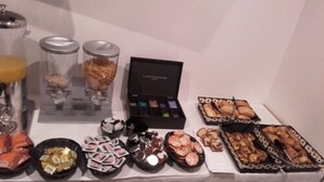Een tafel met diverse etenswaren, zoals gebak, chocolade en lekkernijen.