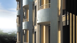A multi-story building with balconies, a flat roof, and a clear sky.