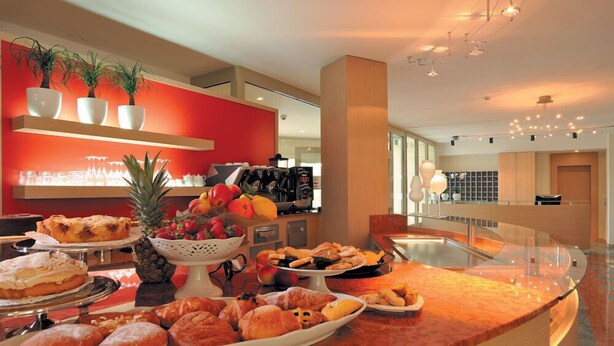 A breakfast buffet with various pastries, fruits, and beverages.