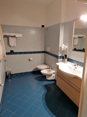 A bathroom with a white sink, a toilet, and a mirror.
