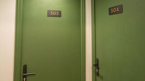 Two green doors with numbers 303 and 304 on them. - Hotel Esperance (Paris)
