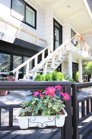 A white building with a wooden staircase leading to a balcony. - Hi Jun Guesthouse (Seoul)