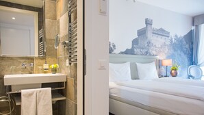 Une salle de bain moderne avec un grand lavabo, un miroir et un porte-serviettes.