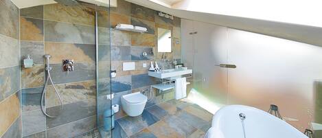 A modern bathroom with a glass-enclosed shower, a freestanding bathtub, and a large mirror.