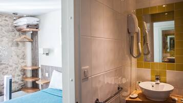 Et moderne badeværelse med en hvid vask, et spejl og en håndklæderadiator.
