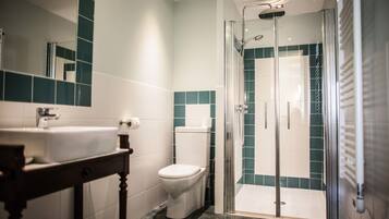Ein Badezimmer mit einer Duschkabine, einer Toilette und einem Waschbecken.