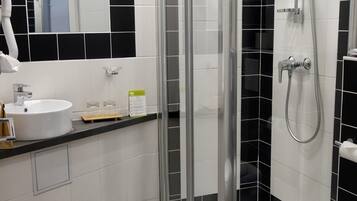 Ein Badezimmer mit Dusche, Waschbecken und Toilette.