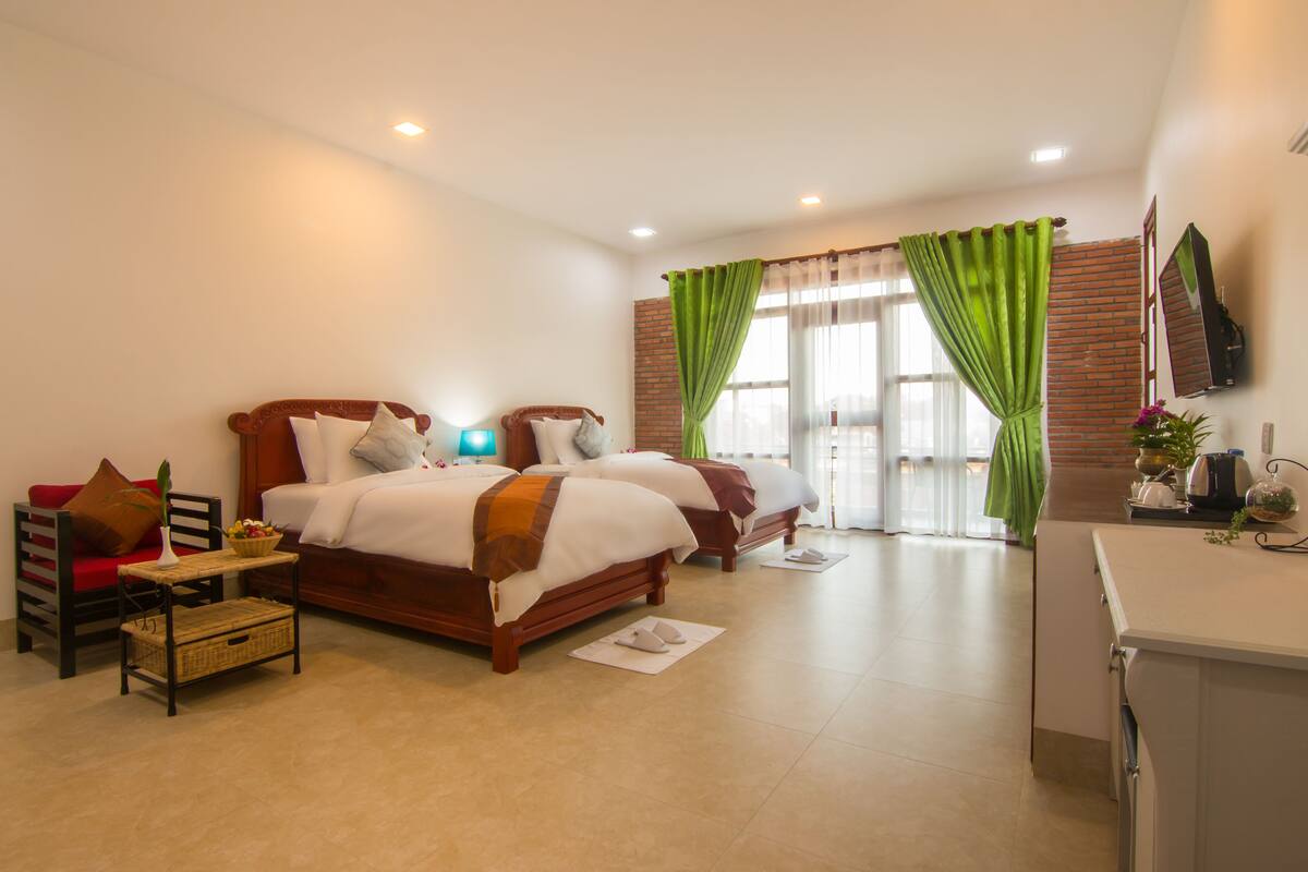 A hotel room with a large bed, a desk, and a chair.