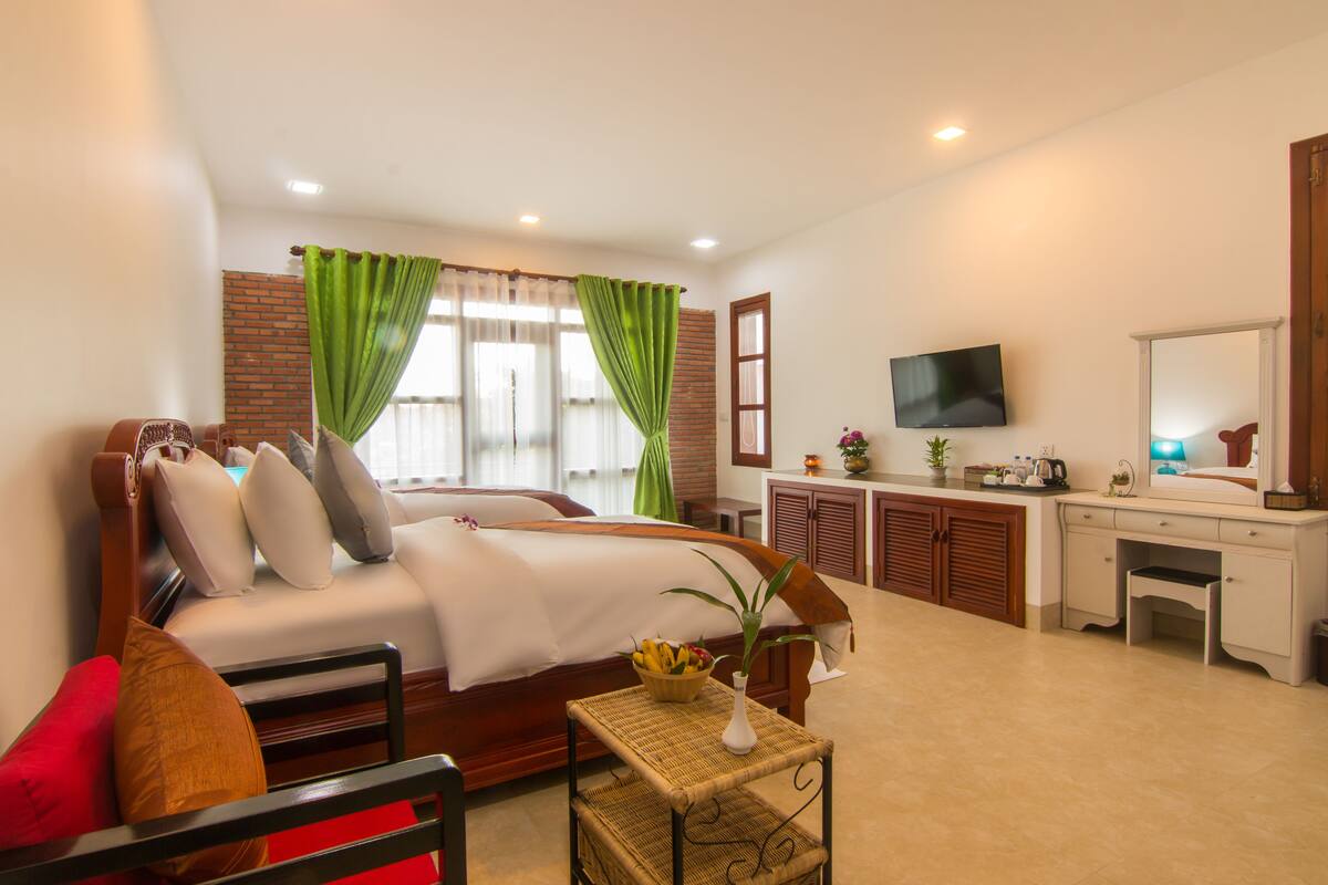 A hotel room with a bed, a desk, a television, and a bathroom.