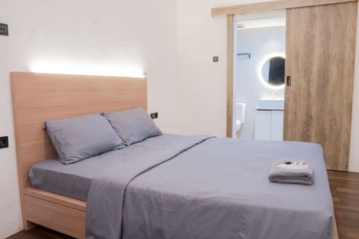 Un dormitorio con cama, mesita de noche y armario.