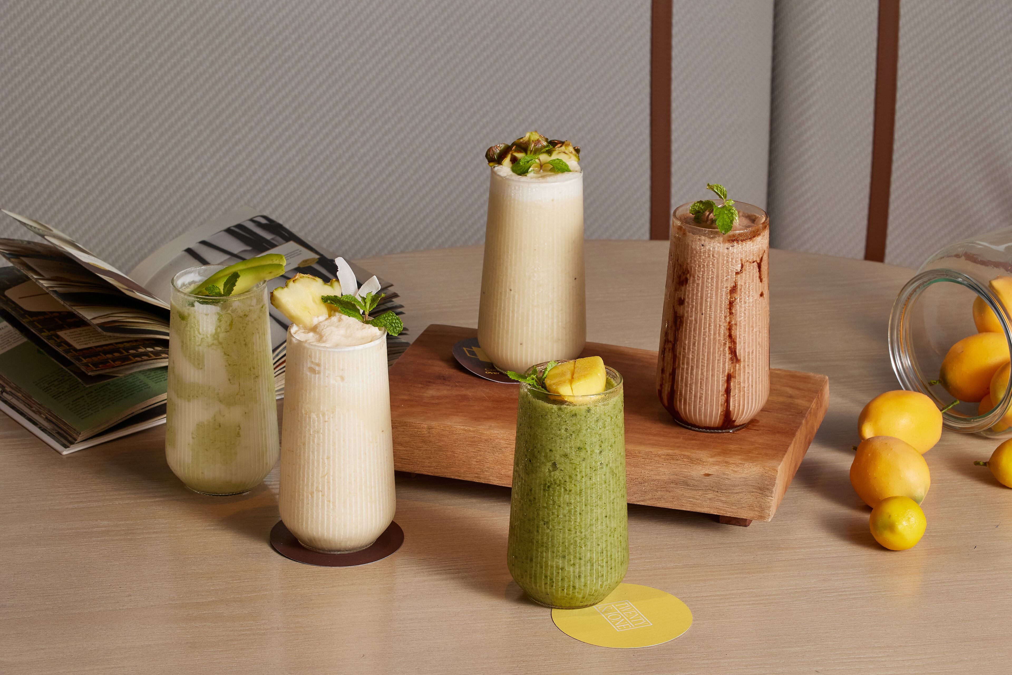 Une table avec diverses boissons, un magazine et quelques citrons.