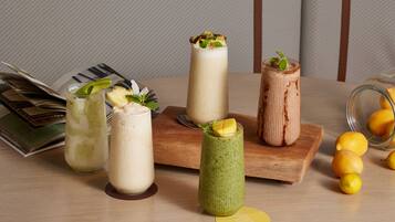 Une table avec diverses boissons, un magazine et quelques citrons.