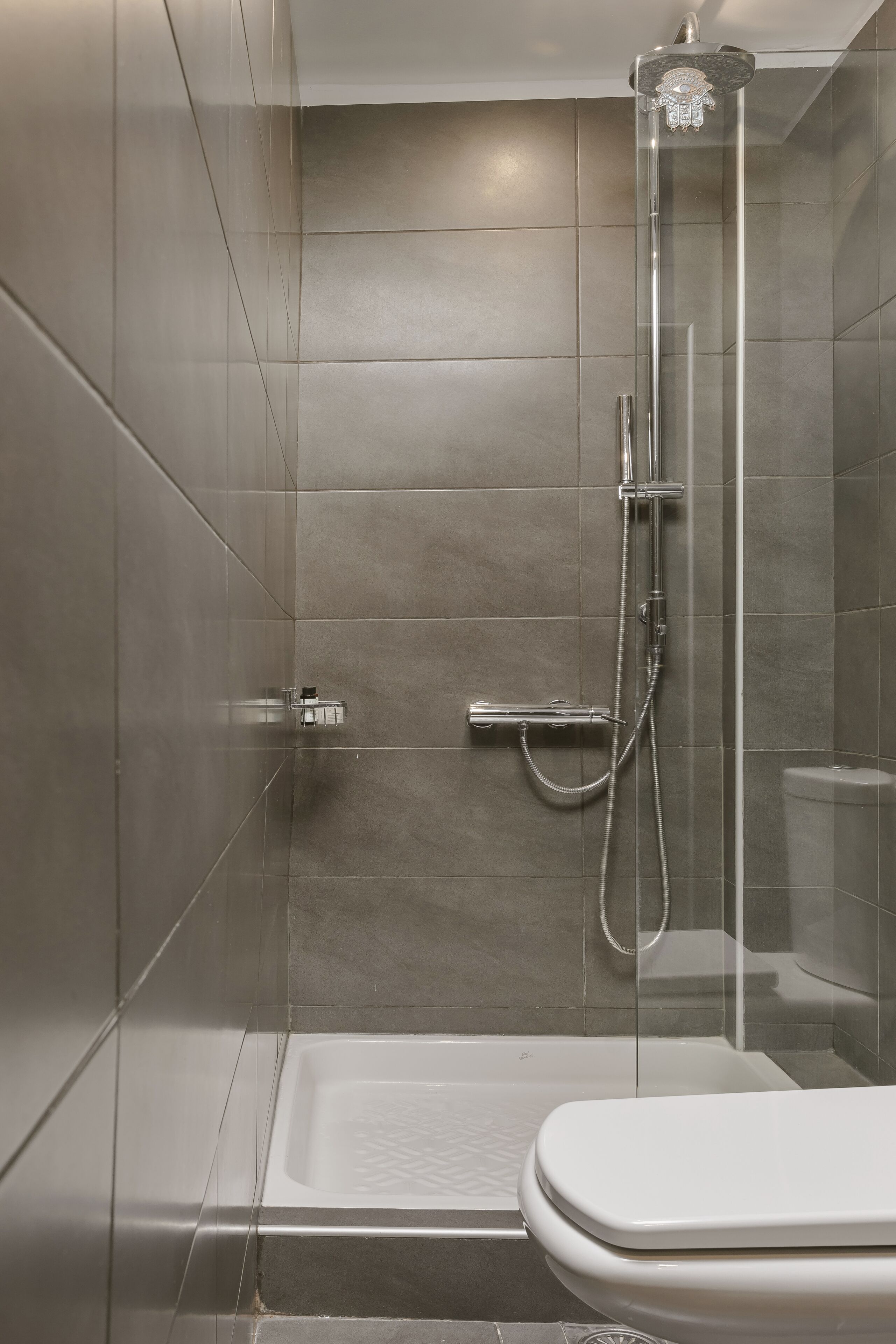 A modern bathroom with a glass-enclosed shower, a separate toilet, and a bathtub.