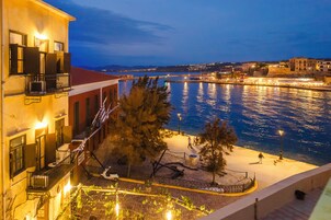 Un hôtel situé au bord de l’eau, doté de balcons, d’une promenade dallée et offrant une vue sur le plan d’eau.
