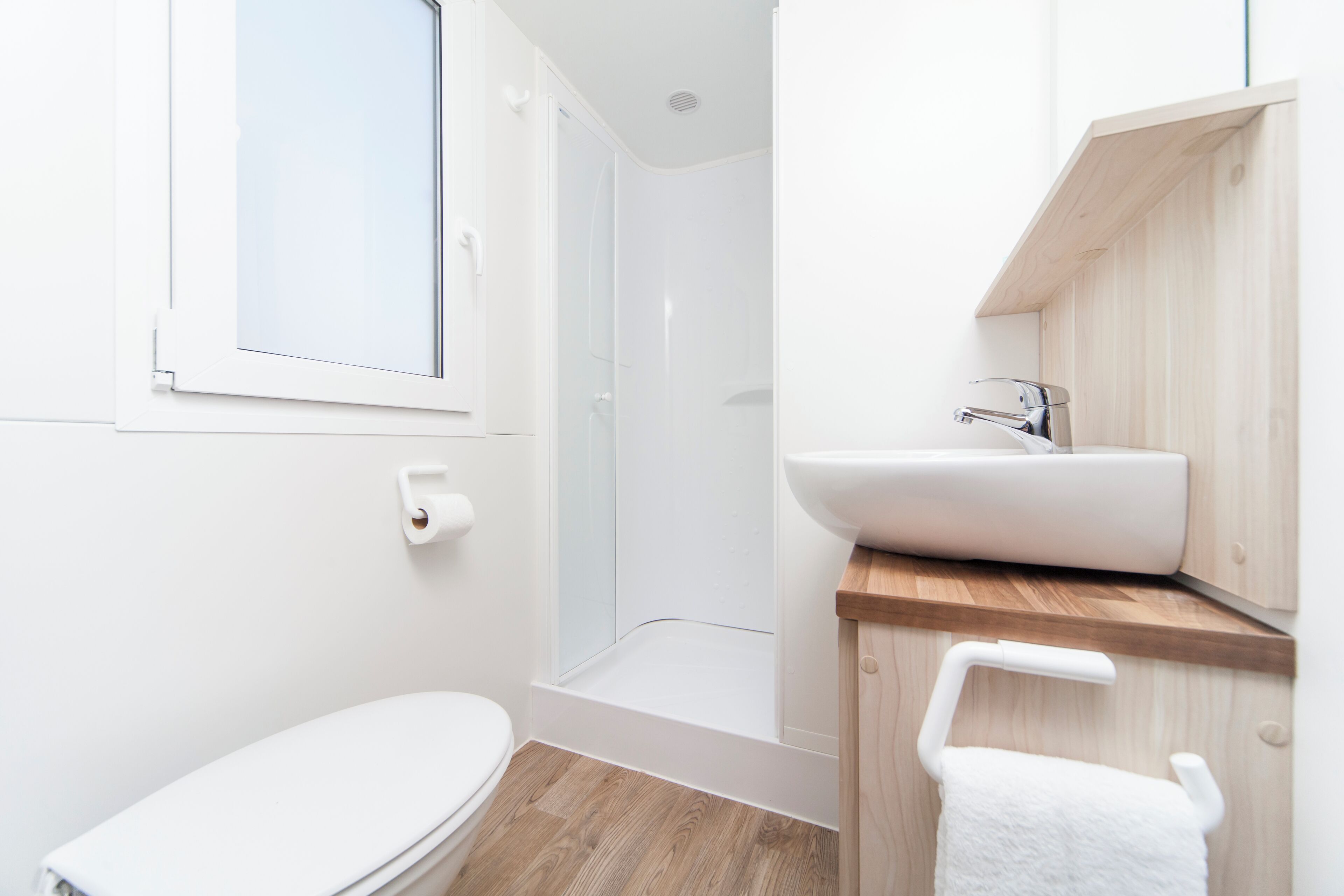 A modern bathroom with a toilet, shower, and sink.