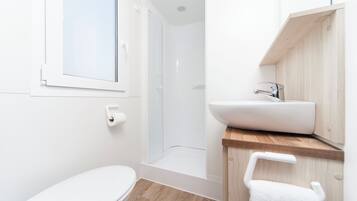 A modern bathroom with a toilet, shower, and sink.