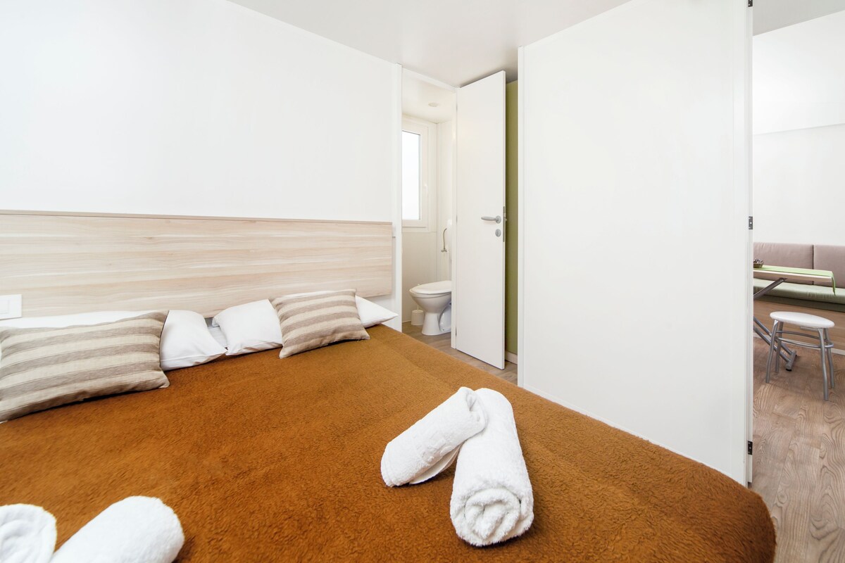 Una habitación de hotel con cama, baño y zona de estar.