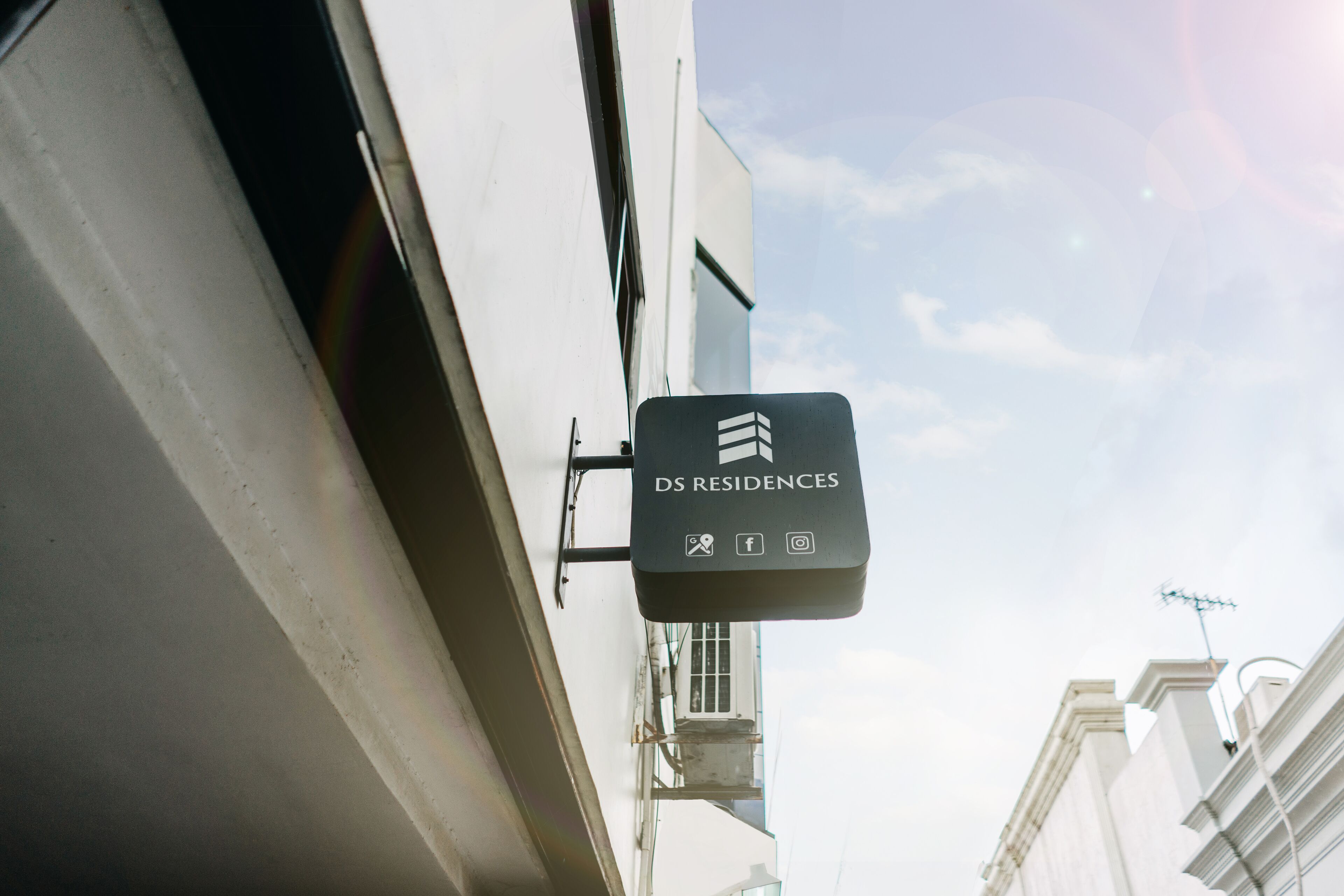 A sign for DS Residences with icons for amenities like Wi-Fi, social media, and a camera.