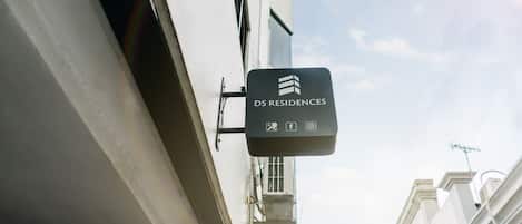 A sign for DS Residences with icons for amenities like Wi-Fi, social media, and a camera.
