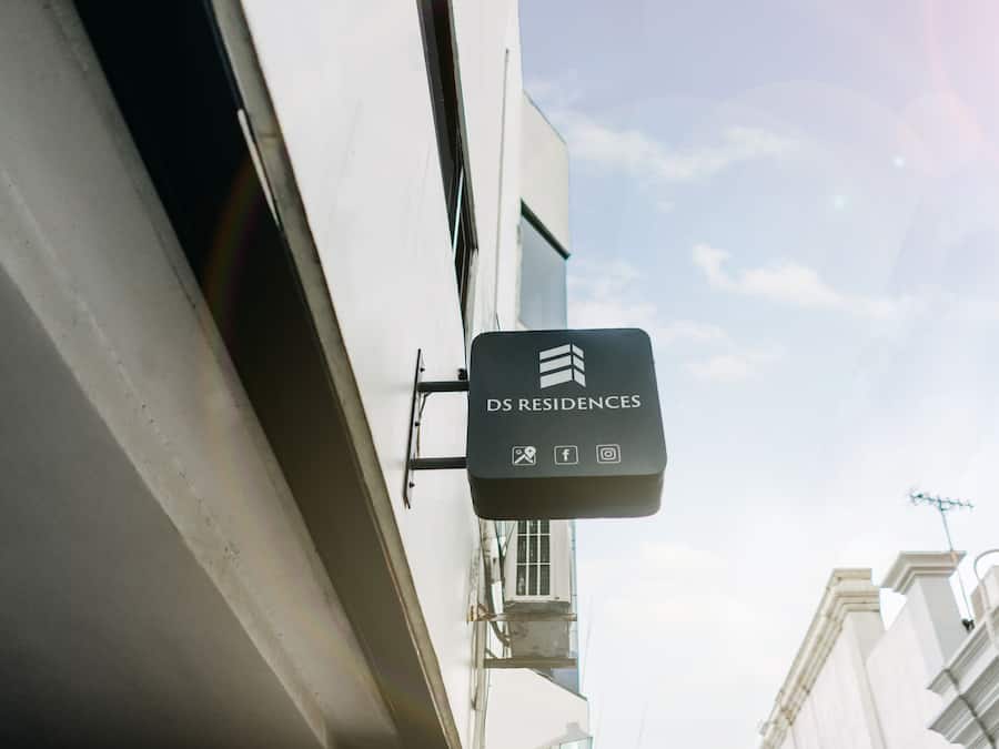 Une enseigne pour DS Residences, avec des icônes représentant les équipements et services proposés, tels que le Wi-Fi, les réseaux sociaux et un appareil photo.