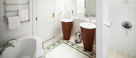 Un baño con bañera, dos lavabos, inodoro, ducha y espejo.