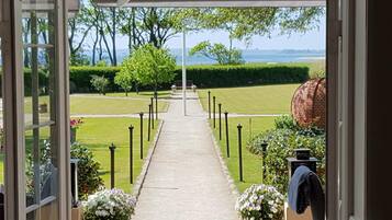 A pathway leading to a landscaped area with a view of the sea.