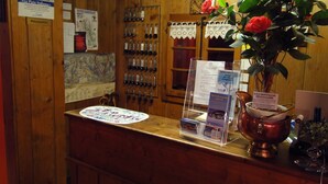 Un comptoir d’accueil en bois, agrémenté d’une carte, d’un porte-clés et d’un vase contenant des fleurs rouges.