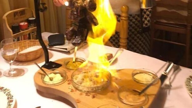 Une personne qui réalise un numéro de jonglage avec du feu en utilisant un plateau rempli de différents aliments.