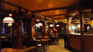 Un restaurant accueillant, avec des meubles en bois, un éclairage chaleureux et un sol carrelé.