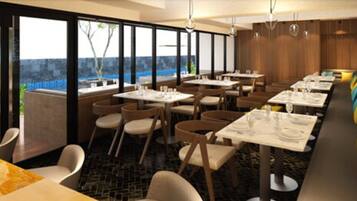 Un restaurante con varias mesas y sillas, ventanas amplias y vistas al exterior.