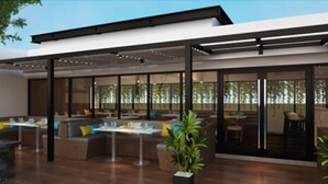 A modern outdoor dining area with multiple tables and seating arrangements. - Louis Kienne Hotel Simpang Lima (Semarang)