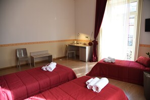 Two single beds with crisp bedding, a compact desk, and a window with a view.