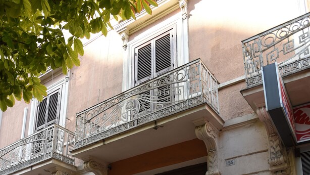 A building with ornate balconies, a storefront with Italian products, and a door with glass panels. - B&B The Queens (Foggia)